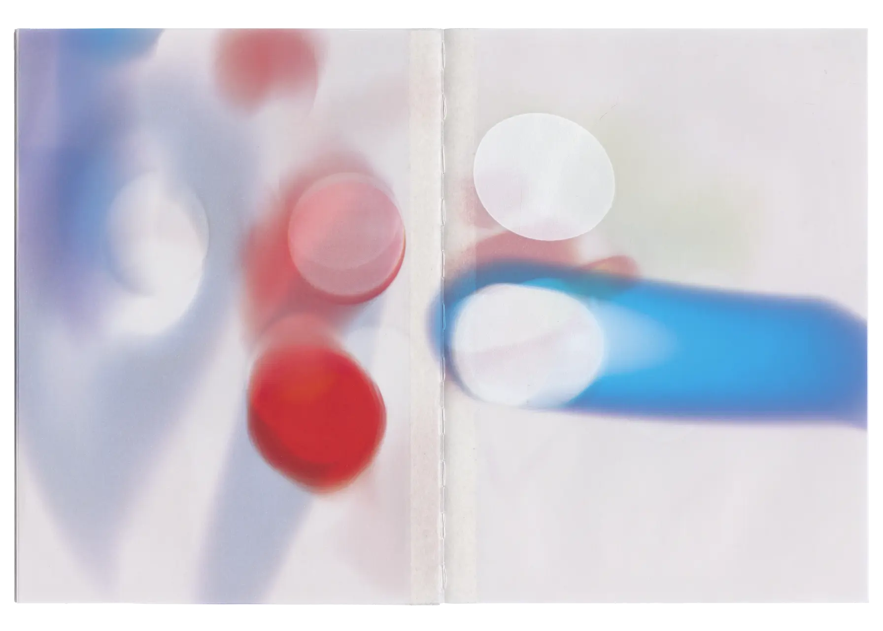 Thirteenth spread of the Bloom book, in this spread is the blur and extracted bloom of a blue car’s red rear brake light. Notably, the images were printed using a UV printer directly onto the pre-bound pages. As a result, the binding thread in the book's seam has taken on some of the color from the images.